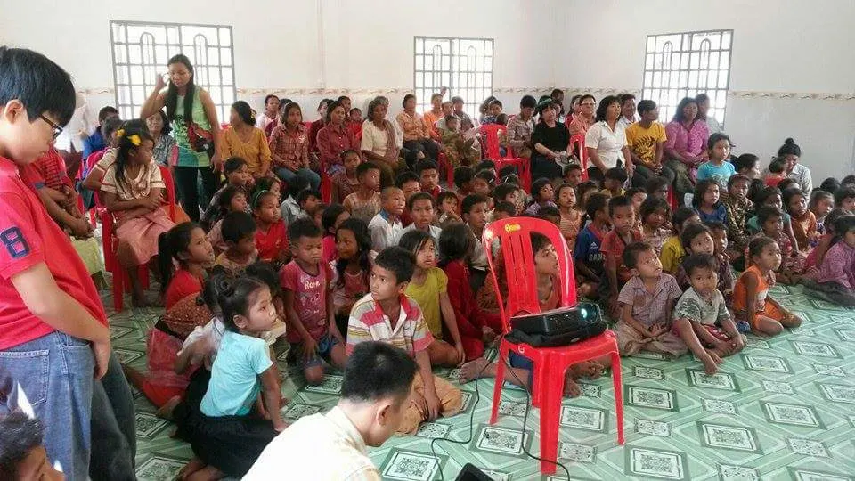 Children and families seated on the floor of the Mission House in Kampong Chhnang, Cambodia